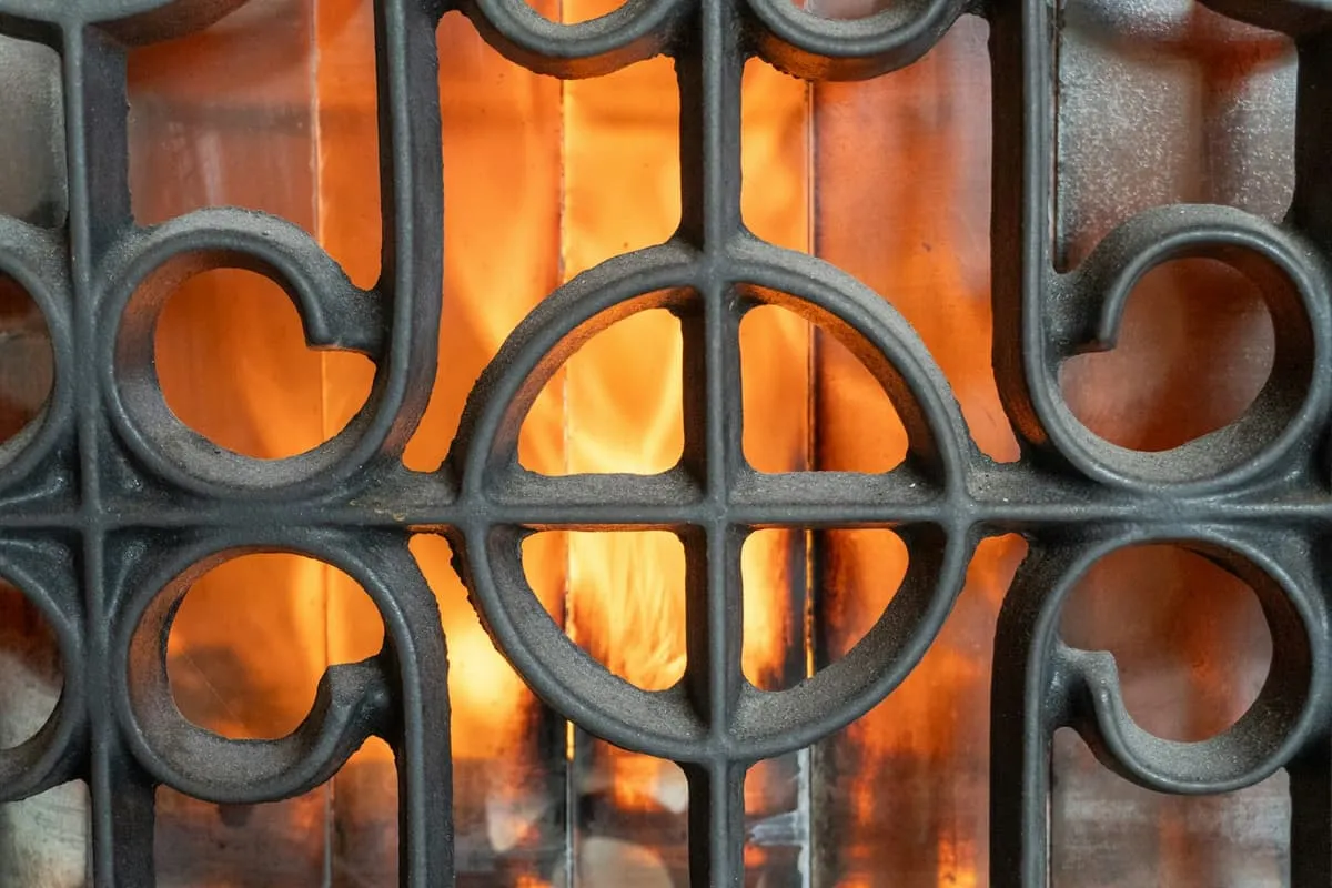 Cast iron fireplace grate with a lit fire in a period home
