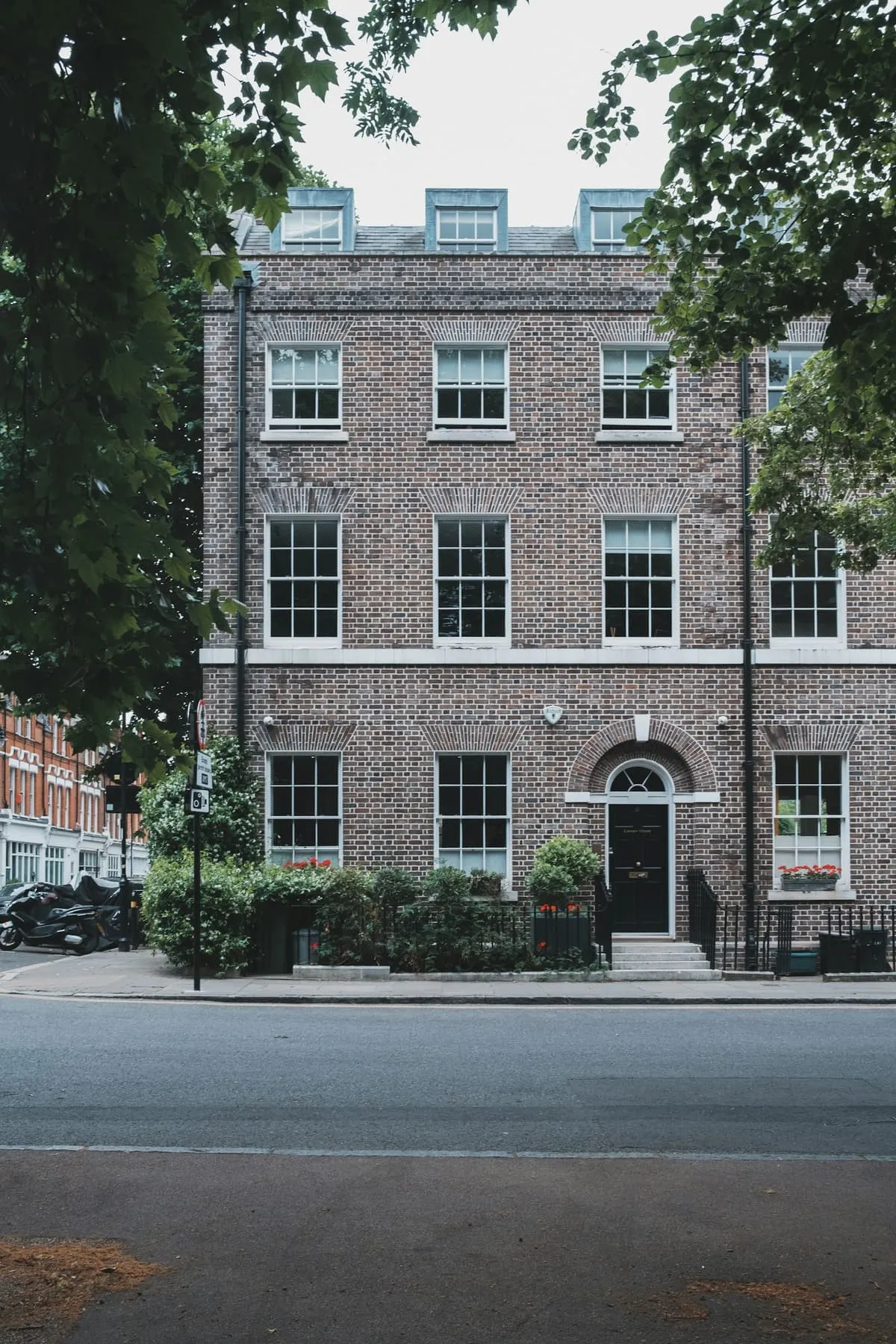 Brick Georgian townhouse with a black front door and fanlight